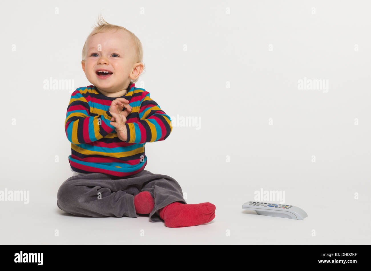 Baby boy playing with remote control, studio shot Stock Photo