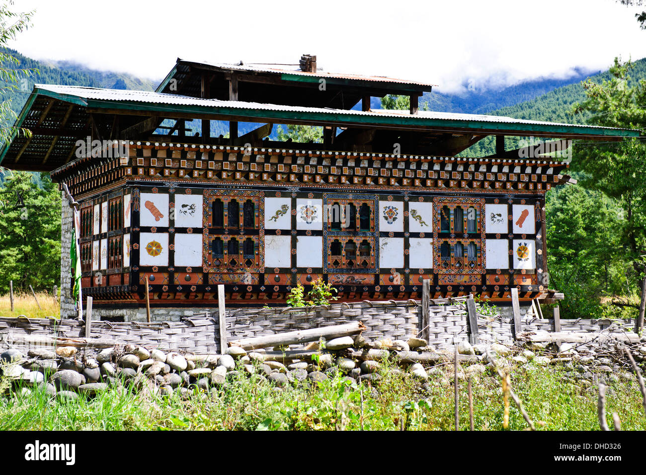 Traditional houses,wall paintings such as large red phallus symbols,animals by colorfully adorned wooden window frames,Bhutan Stock Photo