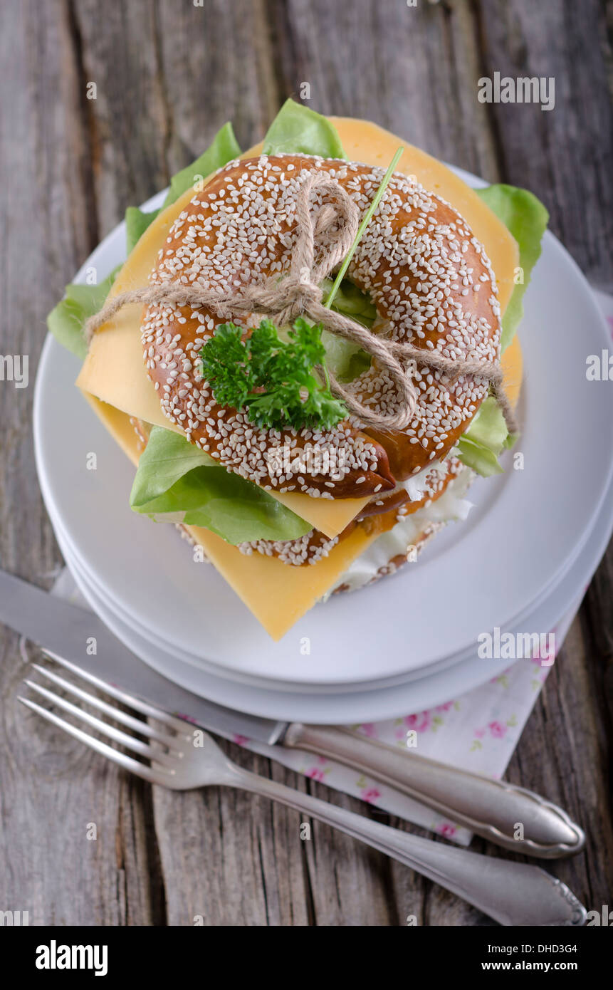 Two sesame bagels with Gouda and lettuce leaf, studio shot Stock Photo