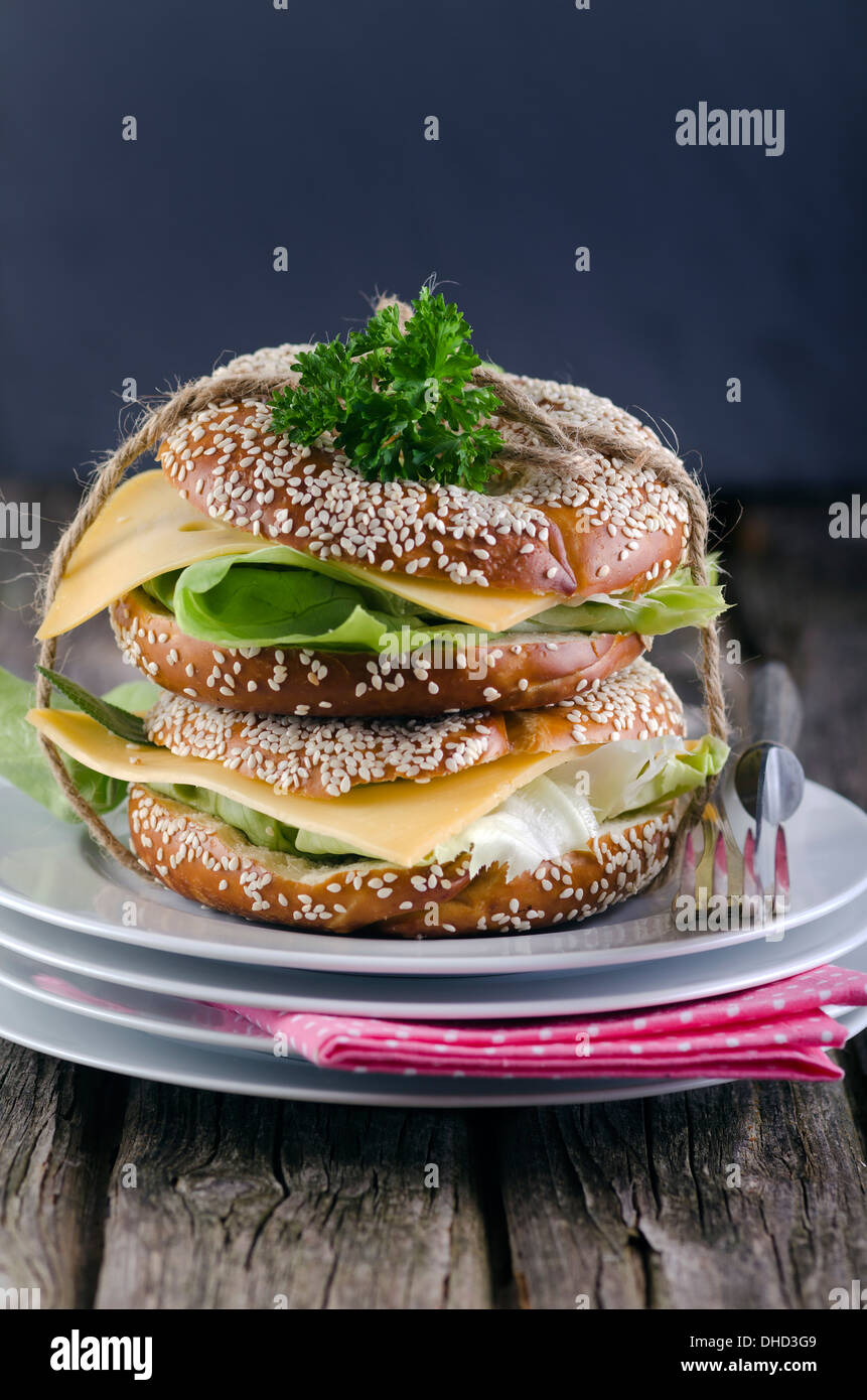 Two sesame bagels with Gouda and lettuce leaf, studio shot Stock Photo
