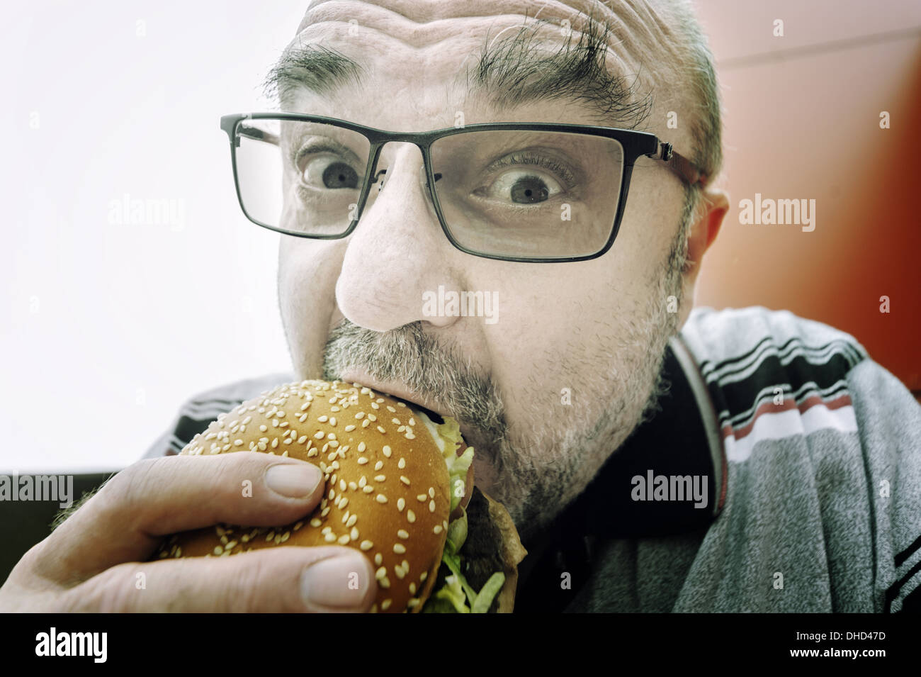 man eats a hamburger Stock Photo