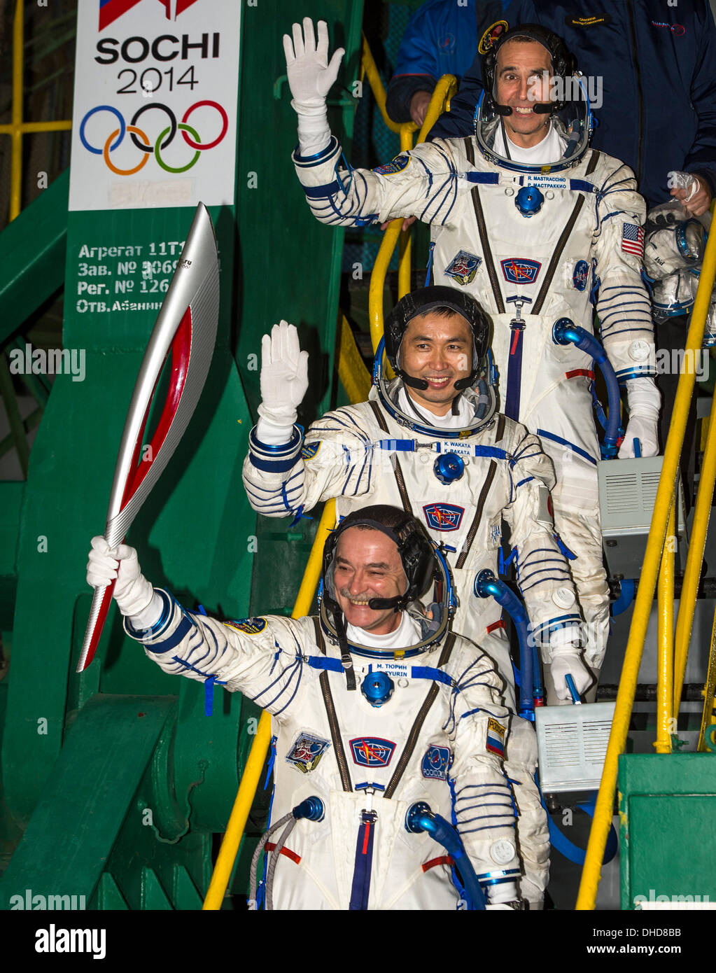 Expedition 38 Soyuz Commander Mikhail Tyurin of Roscosmos, holding the Olympic torch, Flight Engineer Koichi Wakata of the Japan Aerospace Exploration Agency, and, Flight Engineer Rick Mastracchio of NASA top, wave farewell prior to boarding the Soyuz TMA-11M rocket for launch, at the Baikonur Cosmodrome in Kazakhsta on 7 November 2013. The Olympic torch have a four-day visit to the International Space Station. Tyurin, Mastracchio, and, Wakata will spend the next six months aboard the International Space Station. Mandatory Credit: Bill Ingalls / NASA via CNP Stock Photo