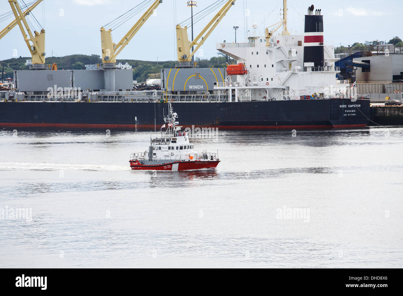 Canadian Coast Guard Vessel sailing past a huge, heavy freighter Stock Photo