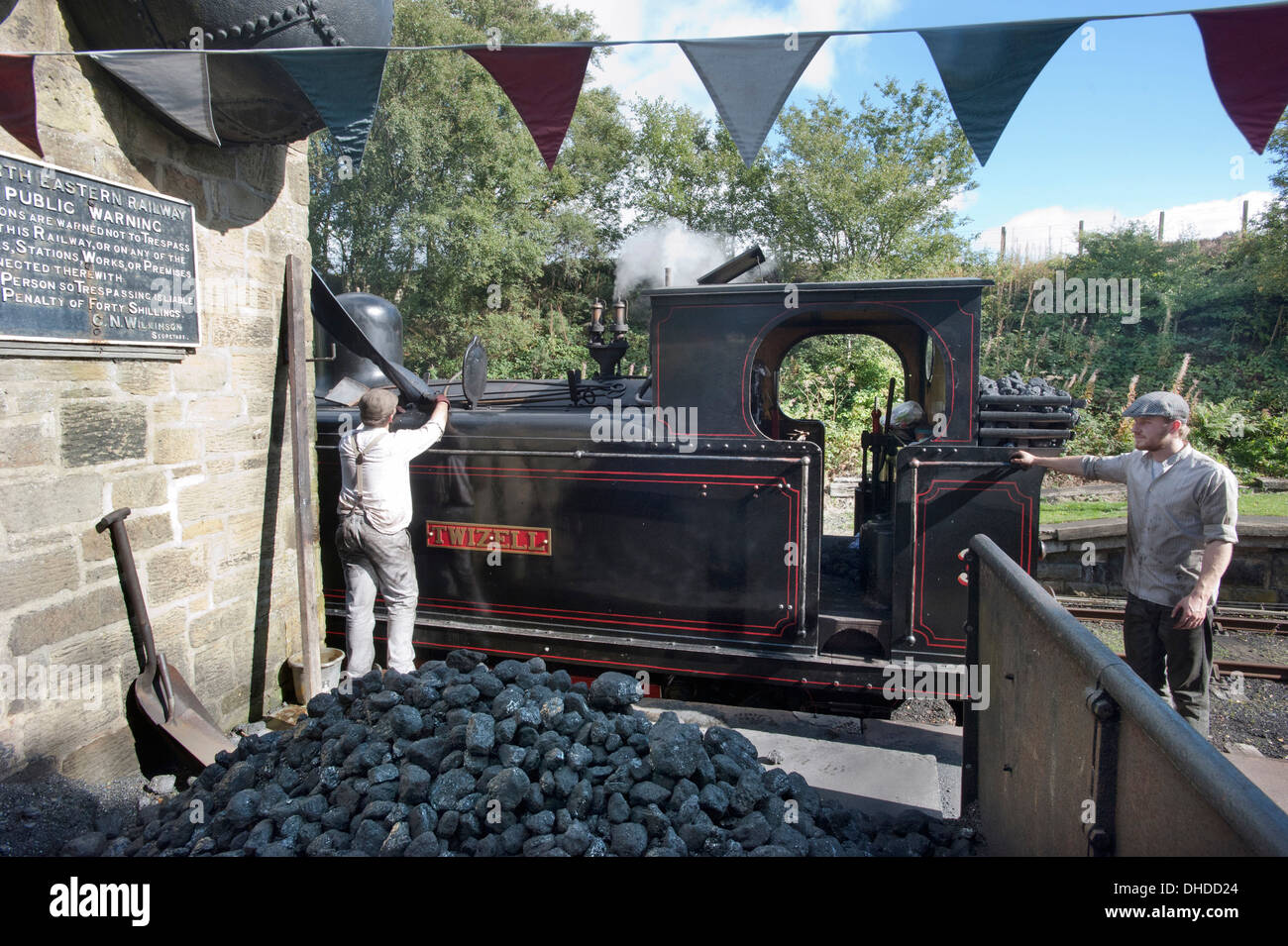 The fireman of former Coal Board tank engine steam locomotive Number 3 'Twizell' fills tanks with water as the driver looks on at Andrews House station on the Tanfield Railway, The Worlds Oldest Railway- Horse drawn, in County Durham. Stock Photo