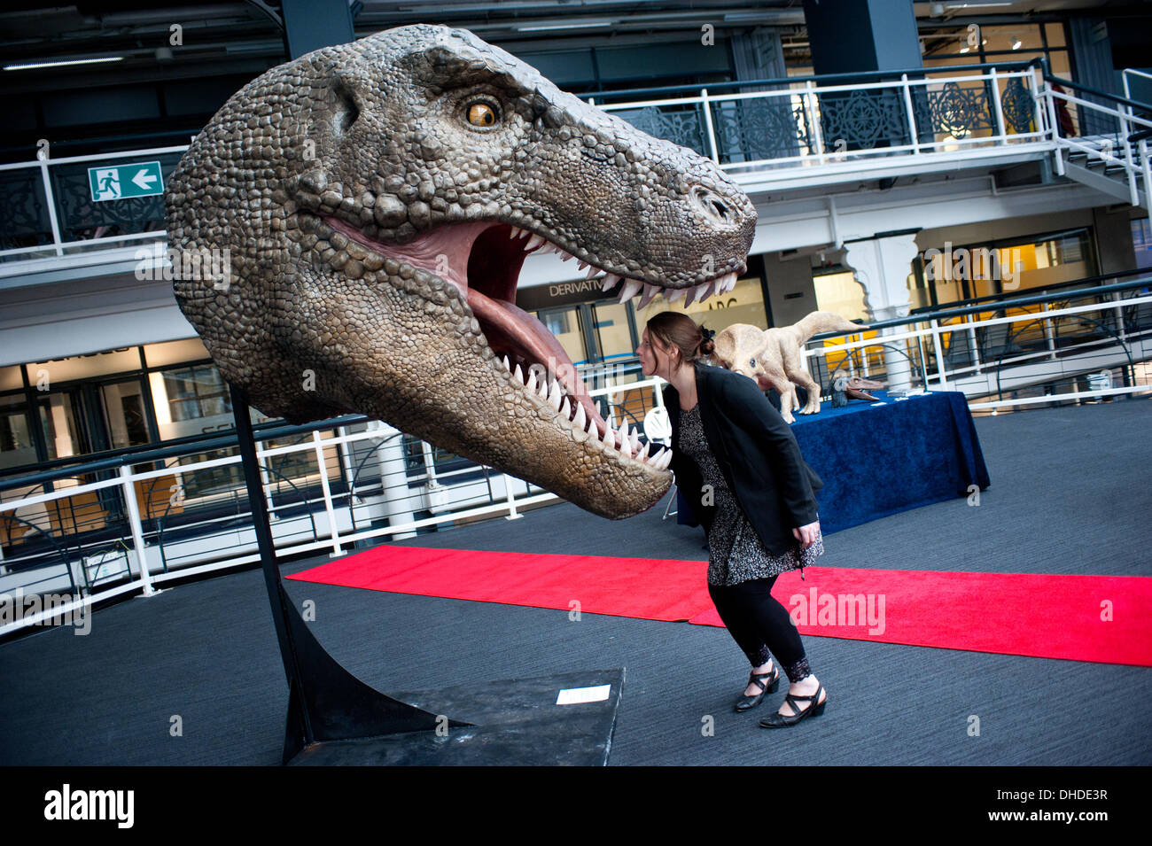 London, UK. 7th November 2013. Cyrielle Langiaux of Crea' Zaurus 3D poses next to a 3D printed Tyrannosaurus Rex head, printed by Arketyp 3D, at the 3D Printshow at the Business Design Centre in London. Credit:  Piero Cruciatti/Alamy Live News Stock Photo