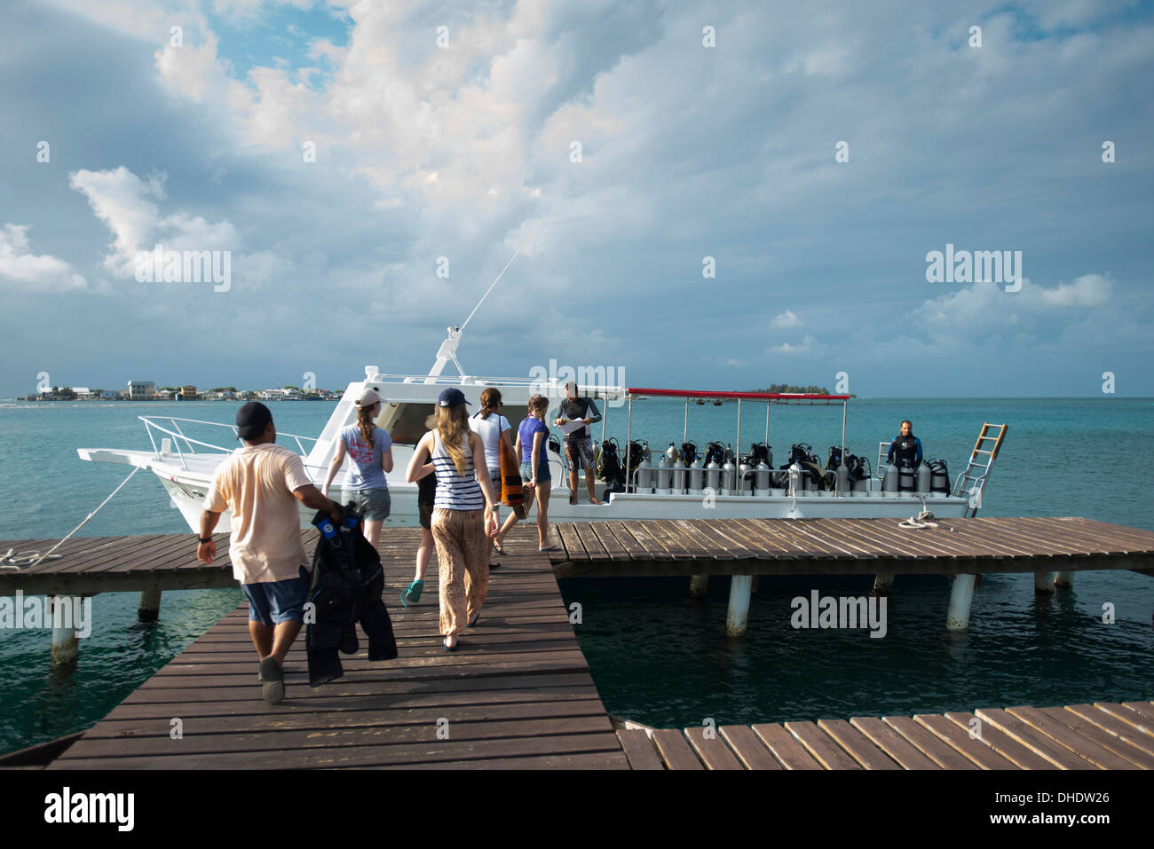 A Group Of Tourists Walk Out To A Scuba Diving Boat; Utila Island, Honduras Stock Photo