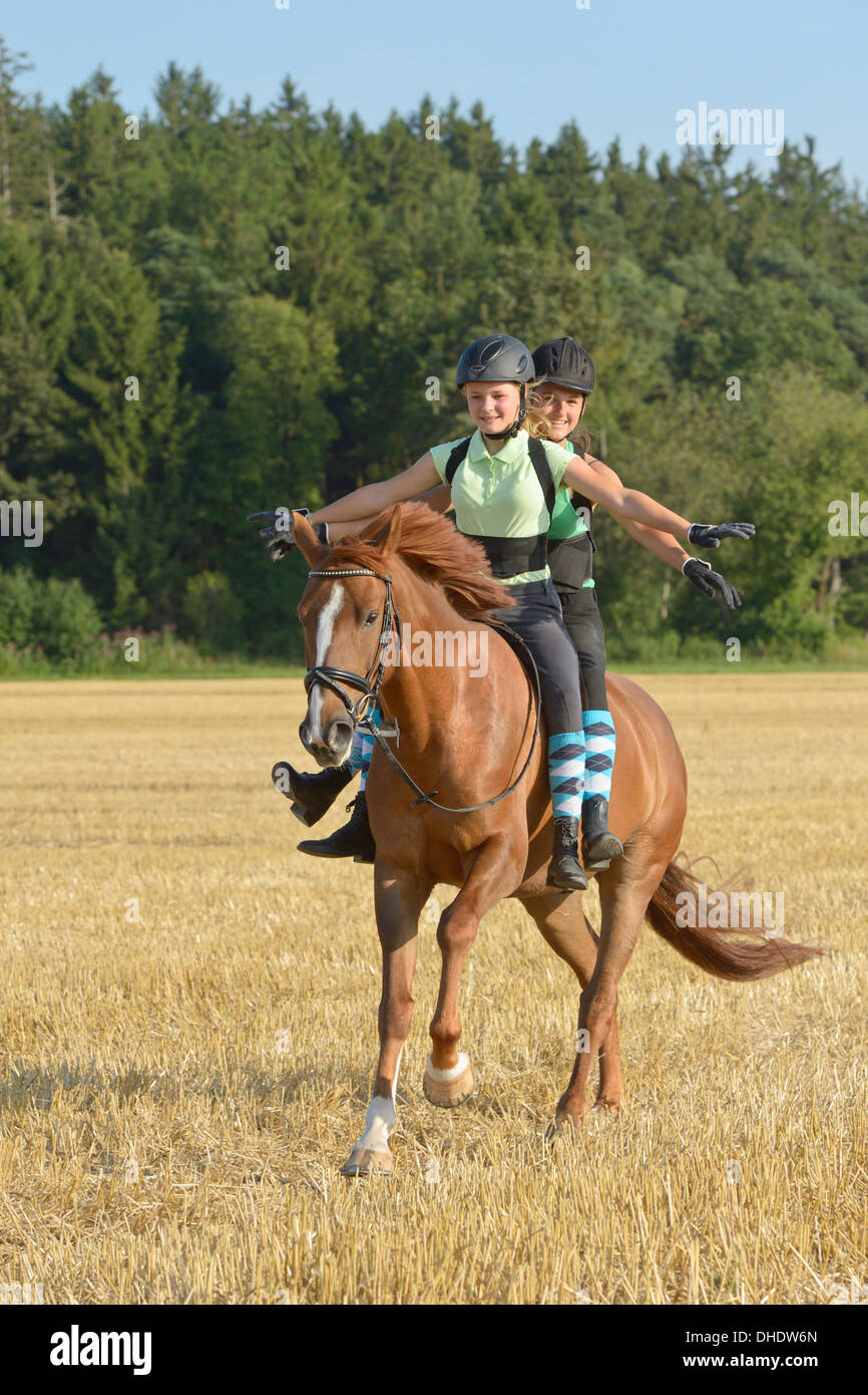 Two girls (wearing helmet and back protector) riding freehand together