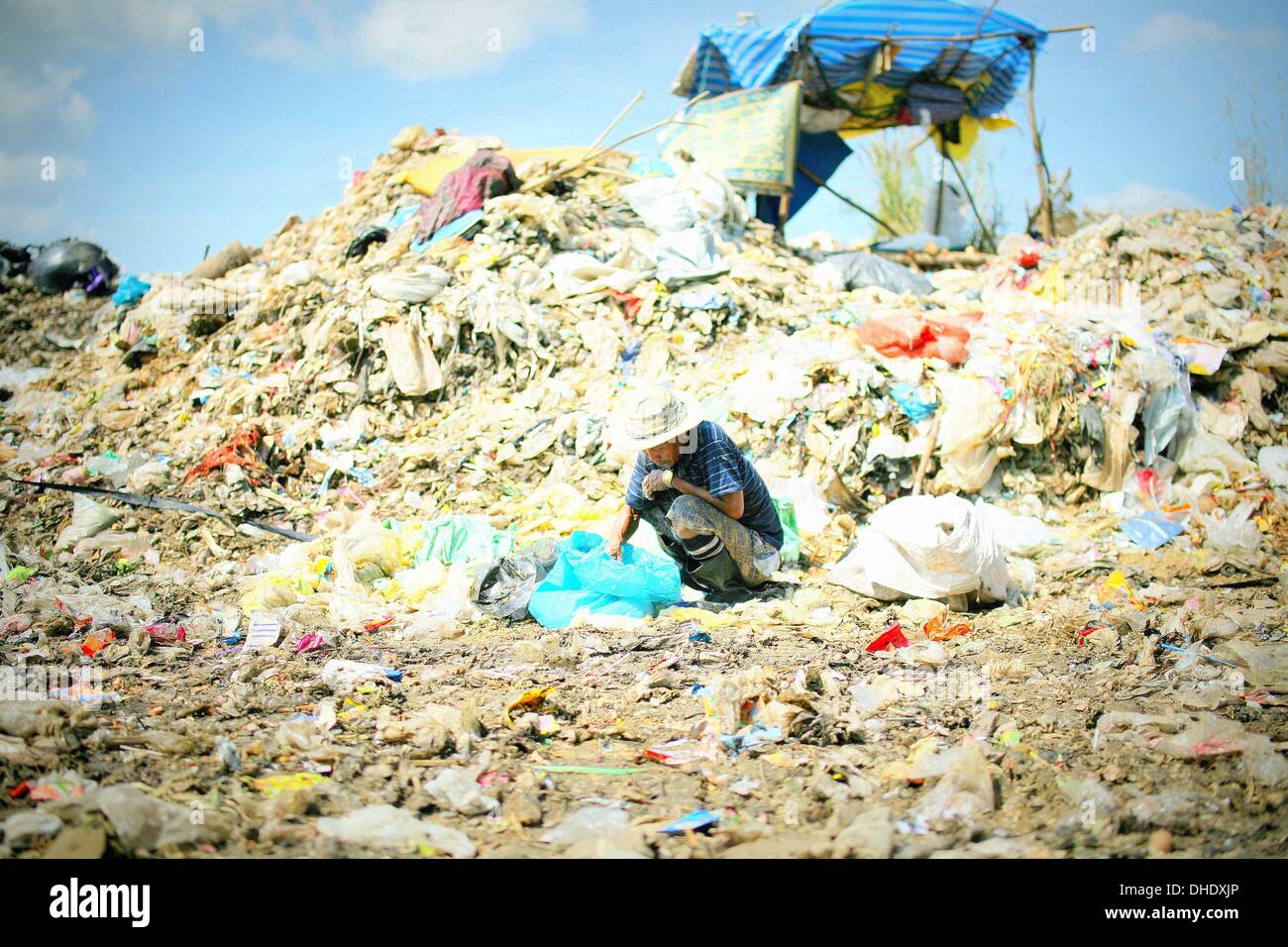 Mae Sot, Tak, Thailand. 7th Nov, 2013. A Burmese man searching at the Mae Sot garbage dump. Tingkaya also known as the City Of Garbage an area roughly the size of a football stadium The poor inhabitants make a living selling recyclable materials like wire, metal, glass, plastic. They heap dwellers survive by eating left-overs and sleep in the same harsh environment which is a breeding ground for bacteria and diseases. Credit:  Rohan Radheya/ZUMA Wire/ZUMAPRESS.com/Alamy Live News Stock Photo