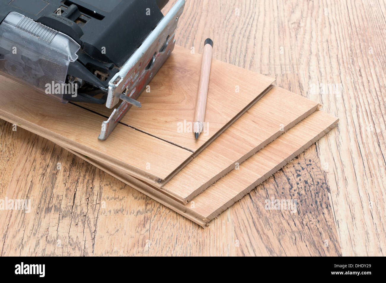 An electric jigsaw resting on some planks of wood effect laminate panels - studio shot Stock Photo