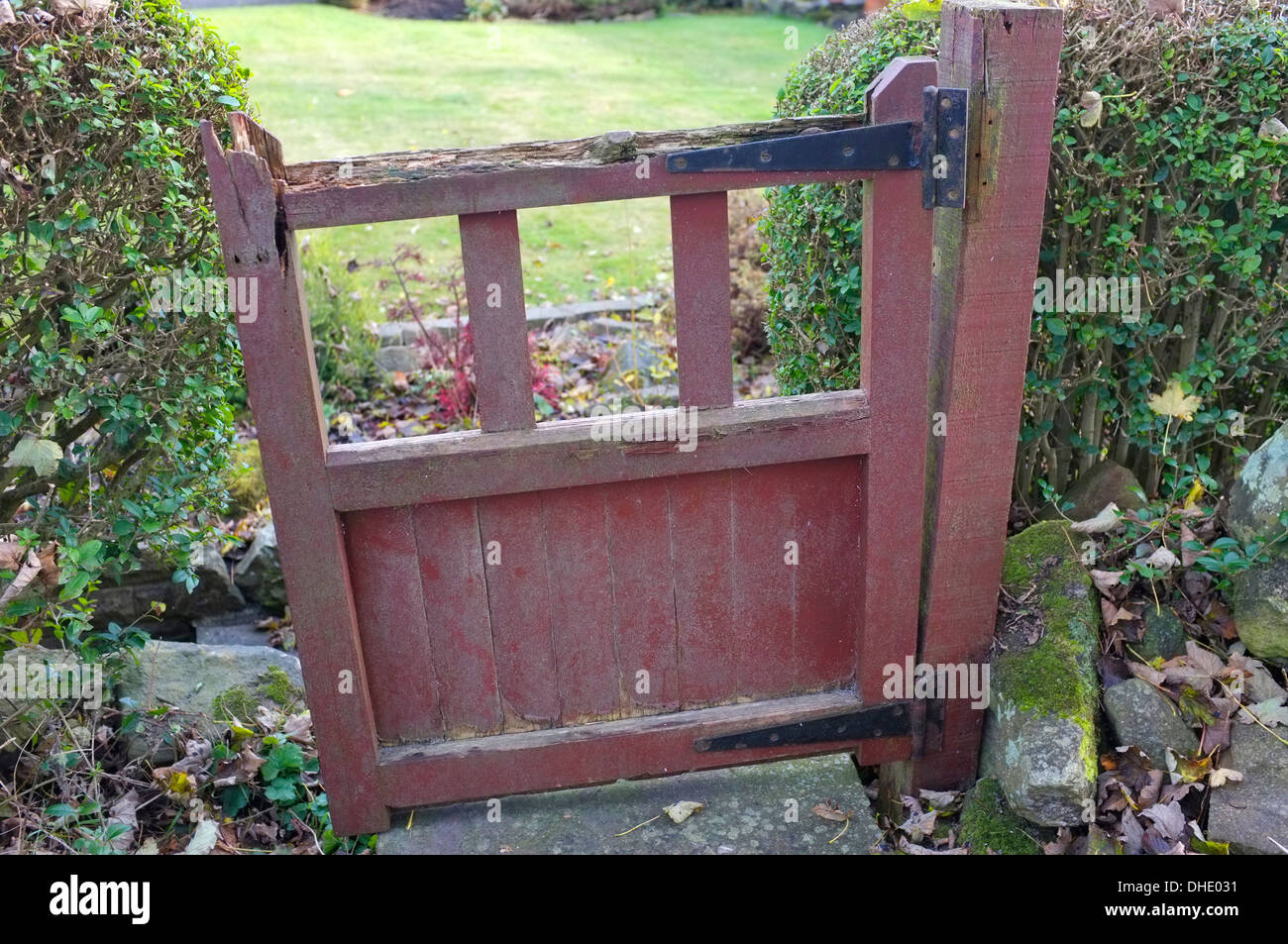 Badly rotted garden gate, falling off its hinges Stock Photo