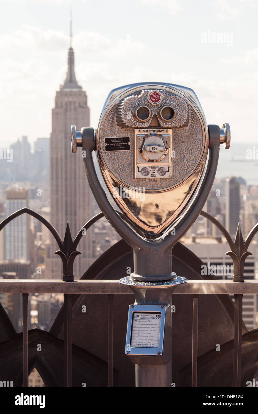Coin operated binoculars on the observation deck of Rockefeller Center with Empire State Building in background, NYC, USA Stock Photo