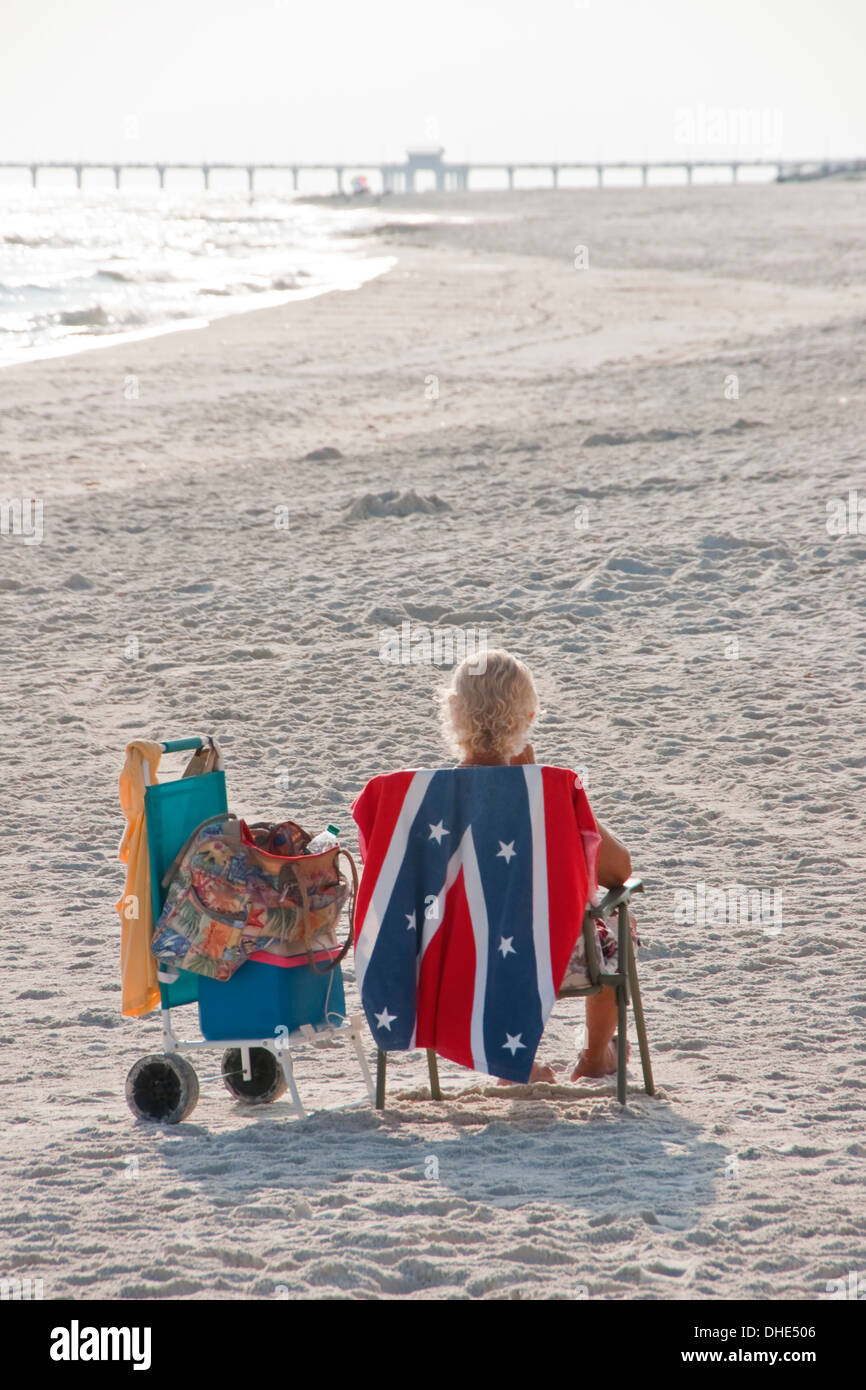 Beach goer with Confederate flag towel on white sand beach at Gulf State Park on Alabama Gulf coast. Stock Photo