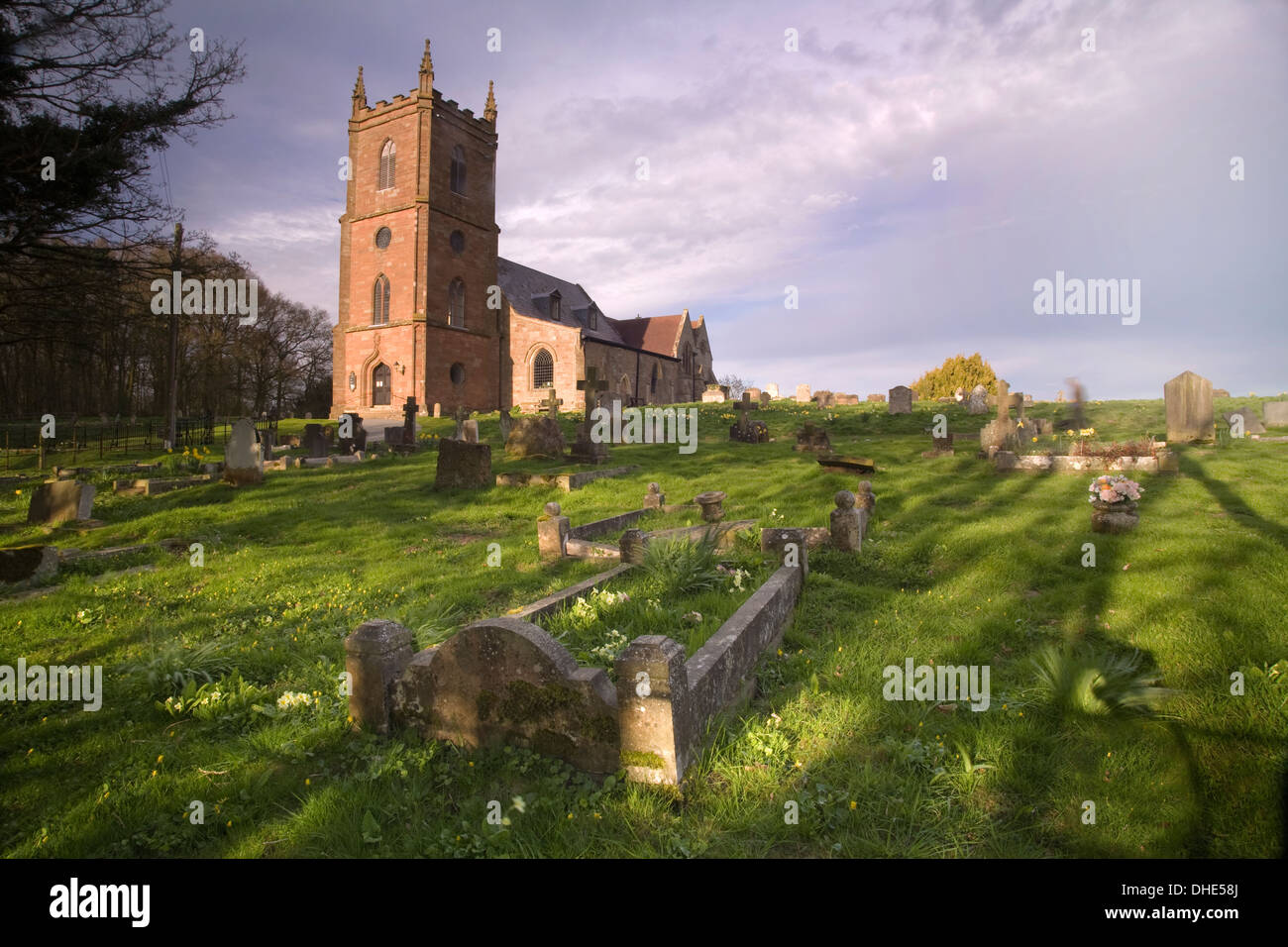 St Mary the Virgin Church Hanbury. The low sun at sunset casts long shadows on the graves in the graveyard. Stock Photo