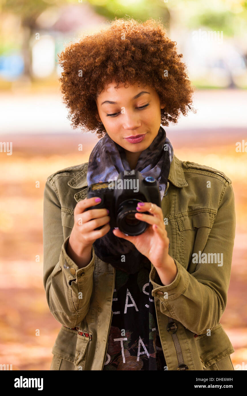 Autumn Outdoor Portrait Of Beautiful African American Young Woman Holding A Digital Camera