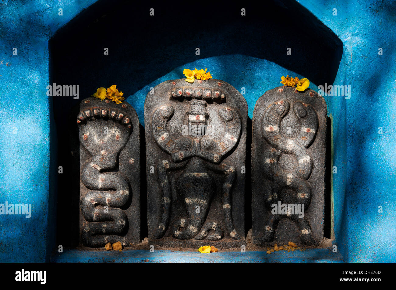 Hindu shrine stones at a temple depicting Indian vishnu deity in rural ...
