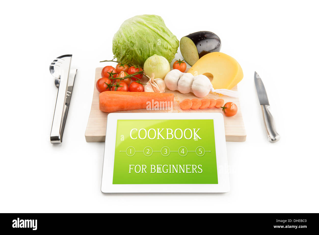 Concept of cookbook for beginners on the tablet computer. Near the tablet computer is a cutting board, cutlery and food. Stock Photo