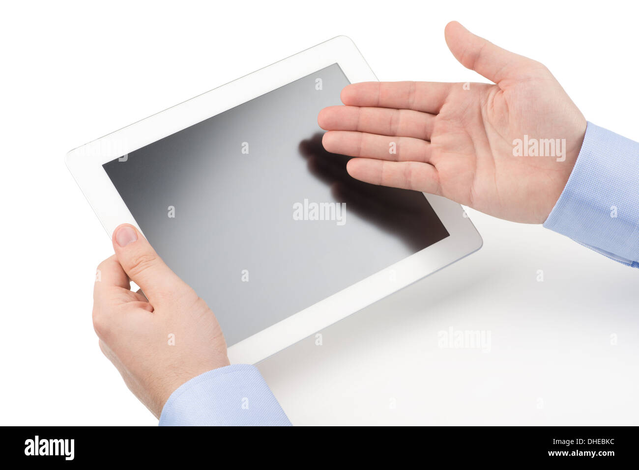 Man holding a tablet computer and directing with other hand toward the screenn on a white background. Stock Photo