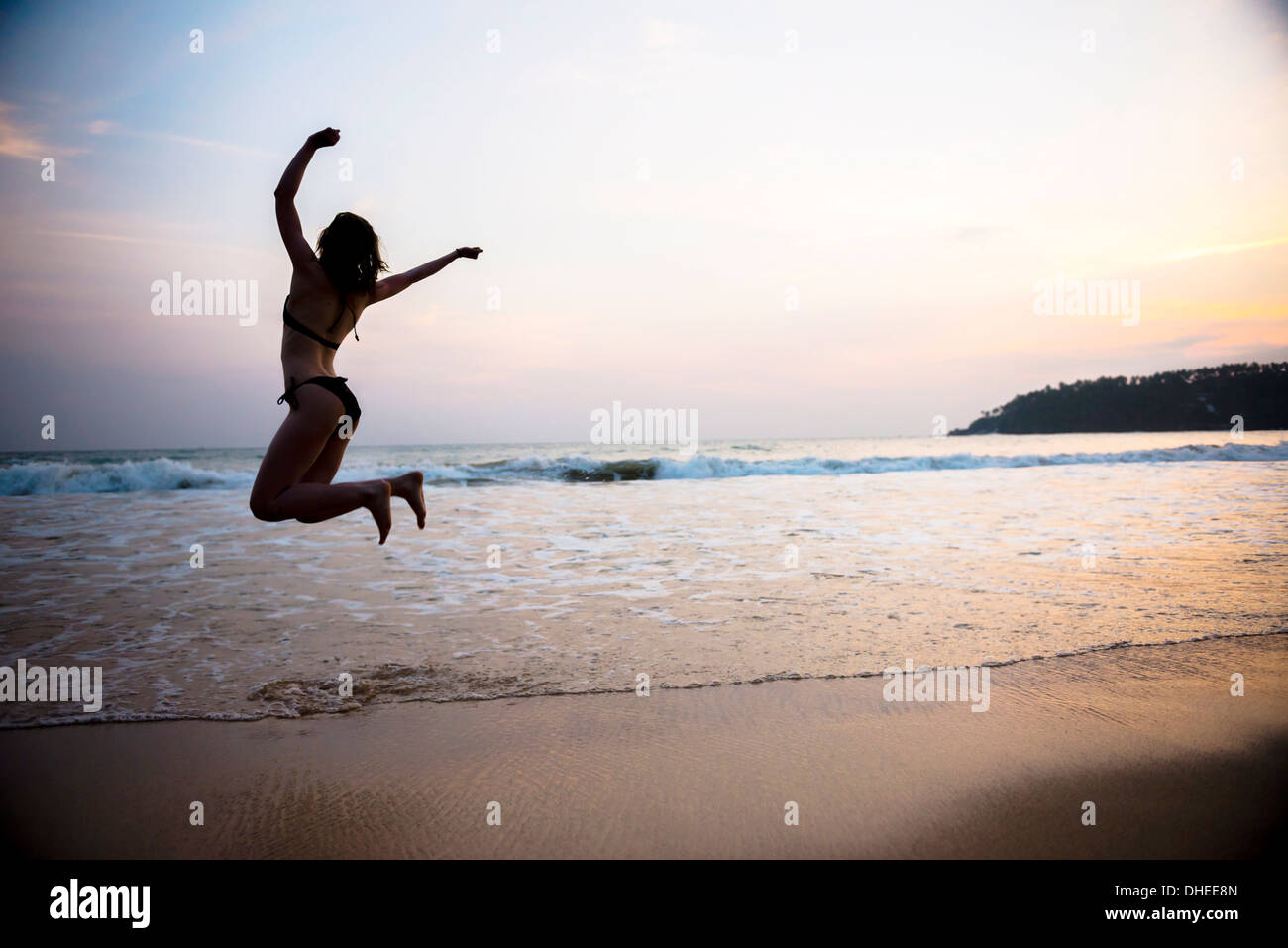 Tourist jumping on Mirissa Beach at sunset, South Coast of Sri Lanka, Southern Province, Sri Lanka, Asia Stock Photo