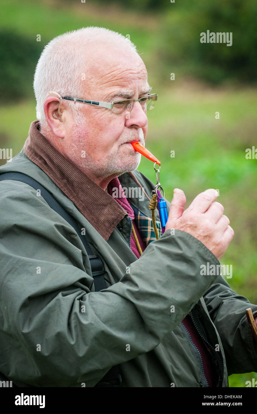 A dog owner, or handler, at a gun dog training day whistling his dog Stock Photo