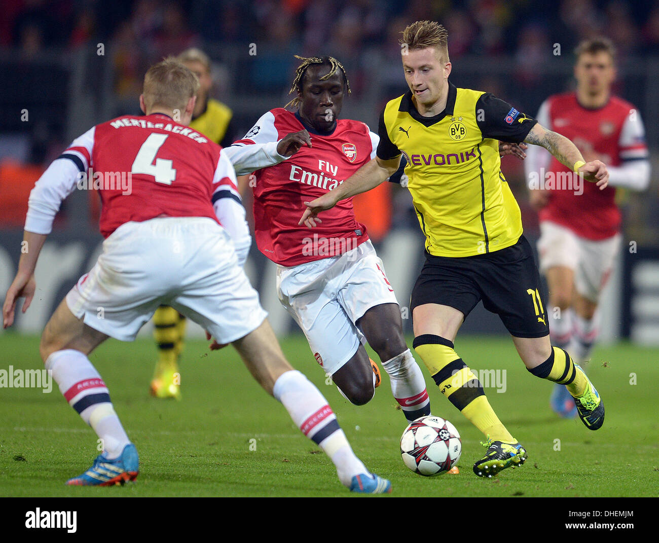 Dortmund, Germany. 06th Nov, 2013. Dortmund's Marco Reus (R) and Arsenals Bacary Sagna (C) and Per Mertesacker vie for the ball during the Champions League soccer match between Borussia Dortmund and FC Arsenal in the BVB stadion in Dortmund, Germany, 06 November 2013. Photo: Federico Gambarini/dpa/Alamy Live News Stock Photo