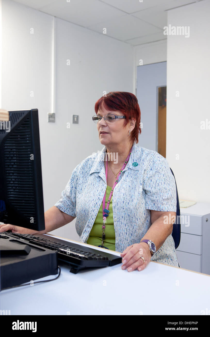 A female receptionist at an outpatient clinic UK Stock Photo