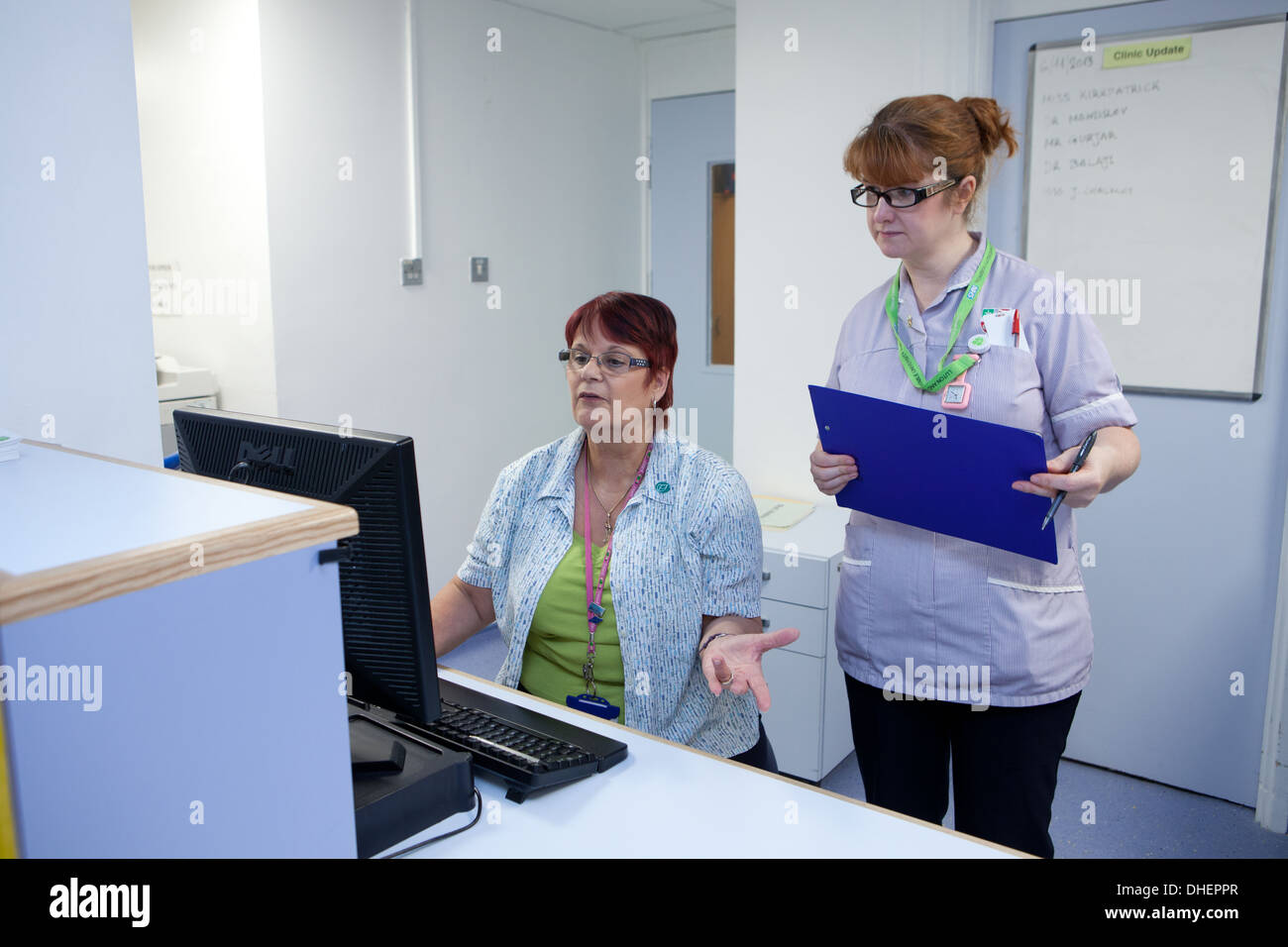 Hospital receptionists check appointments in an outpatient depatment UK Stock Photo