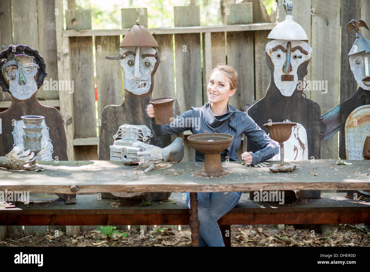 Woman at table with sculptures, Nervous Nellies sculpture garden, Deer