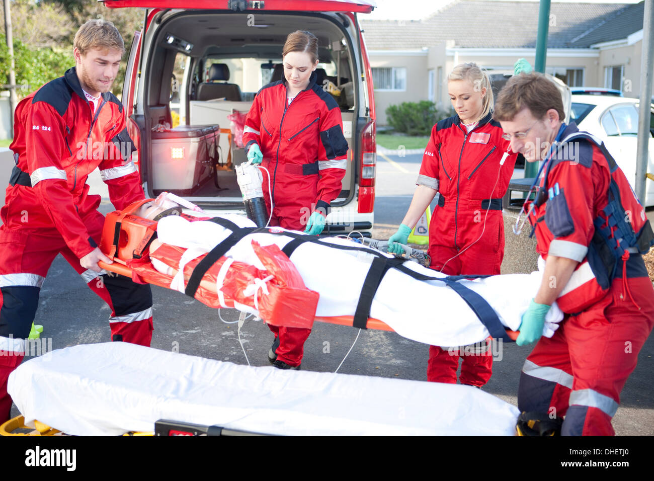 Paramedics lifting woman on stretcher hires stock photography and