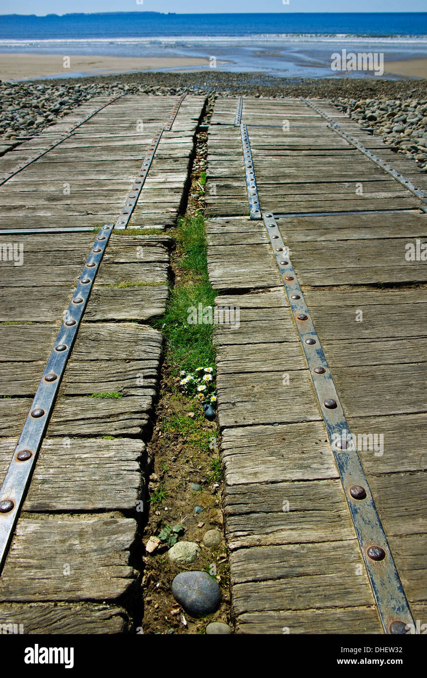 wooden pathways across pebbles leading to beach sand and sea on Newgale Sands Wales Stock Photo