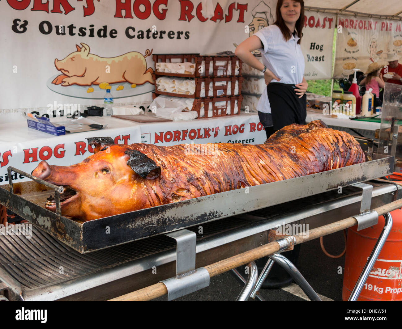 Hog roast pig stall on open air market with girl standing in background Stock Photo
