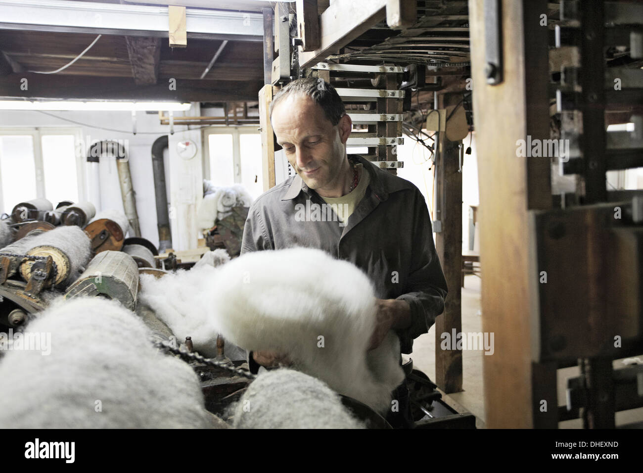 Worker looking at fleece in wool factory Stock Photo