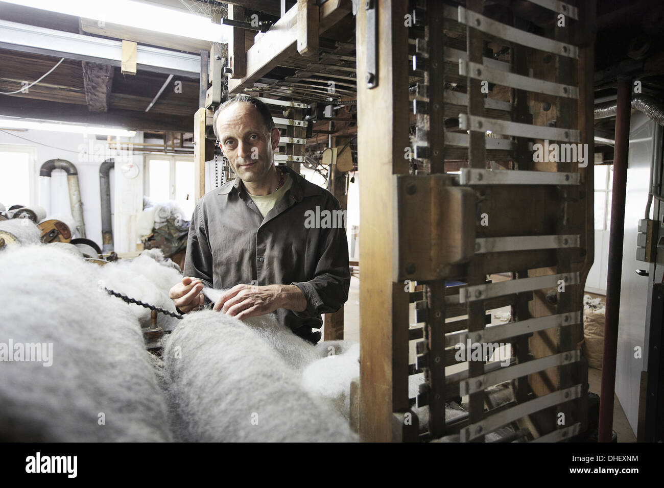 Worker with fleece in wool factory Stock Photo