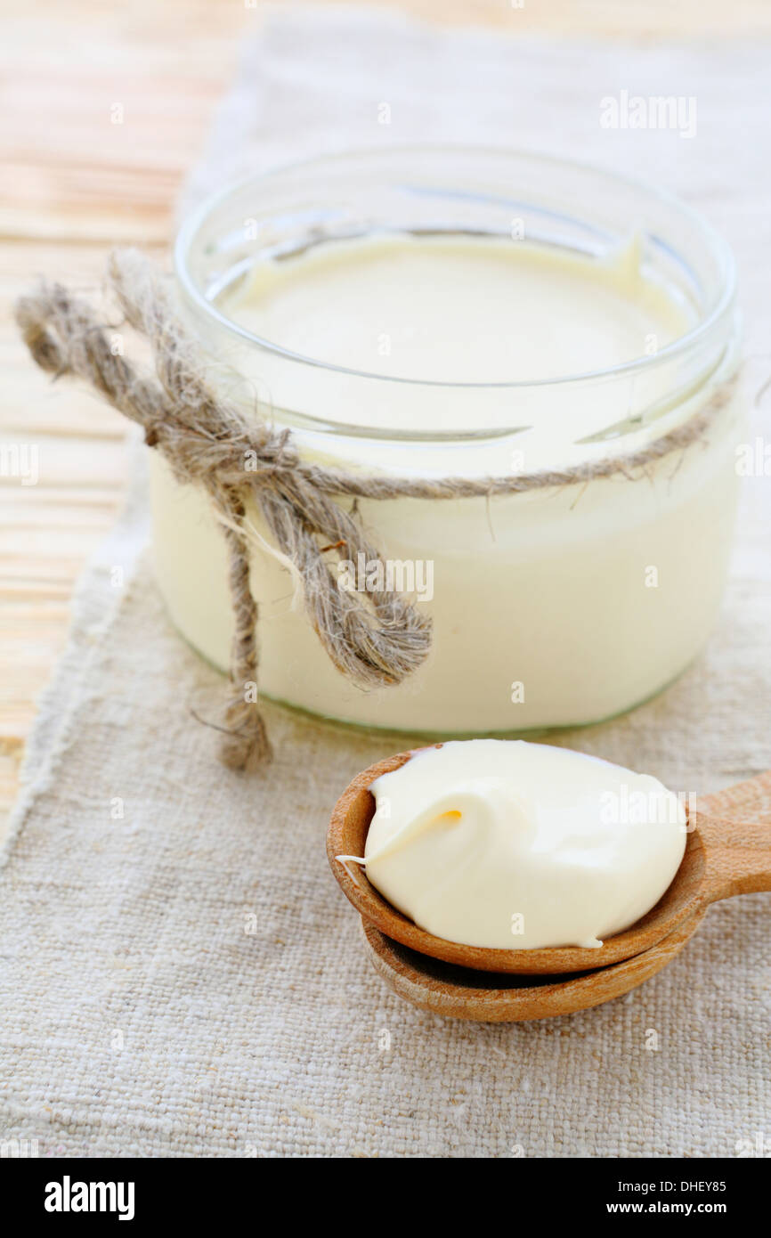 homemade sour cream in a jar and on spoon, food Stock Photo