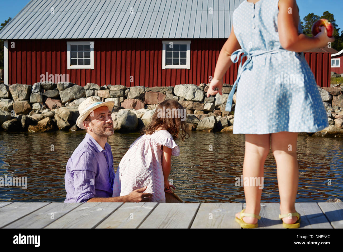 Father and two girls on pier, Utvalnas, Gavle, Sweden Stock Photo
