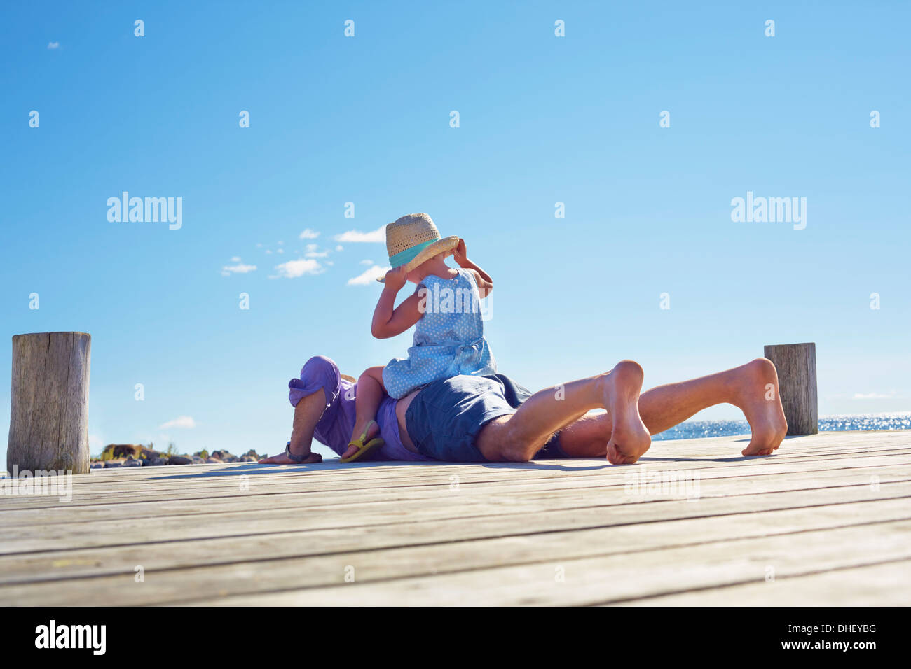 Female toddler and father on jetty, Utvalnas, Gavle, Sweden Stock Photo
