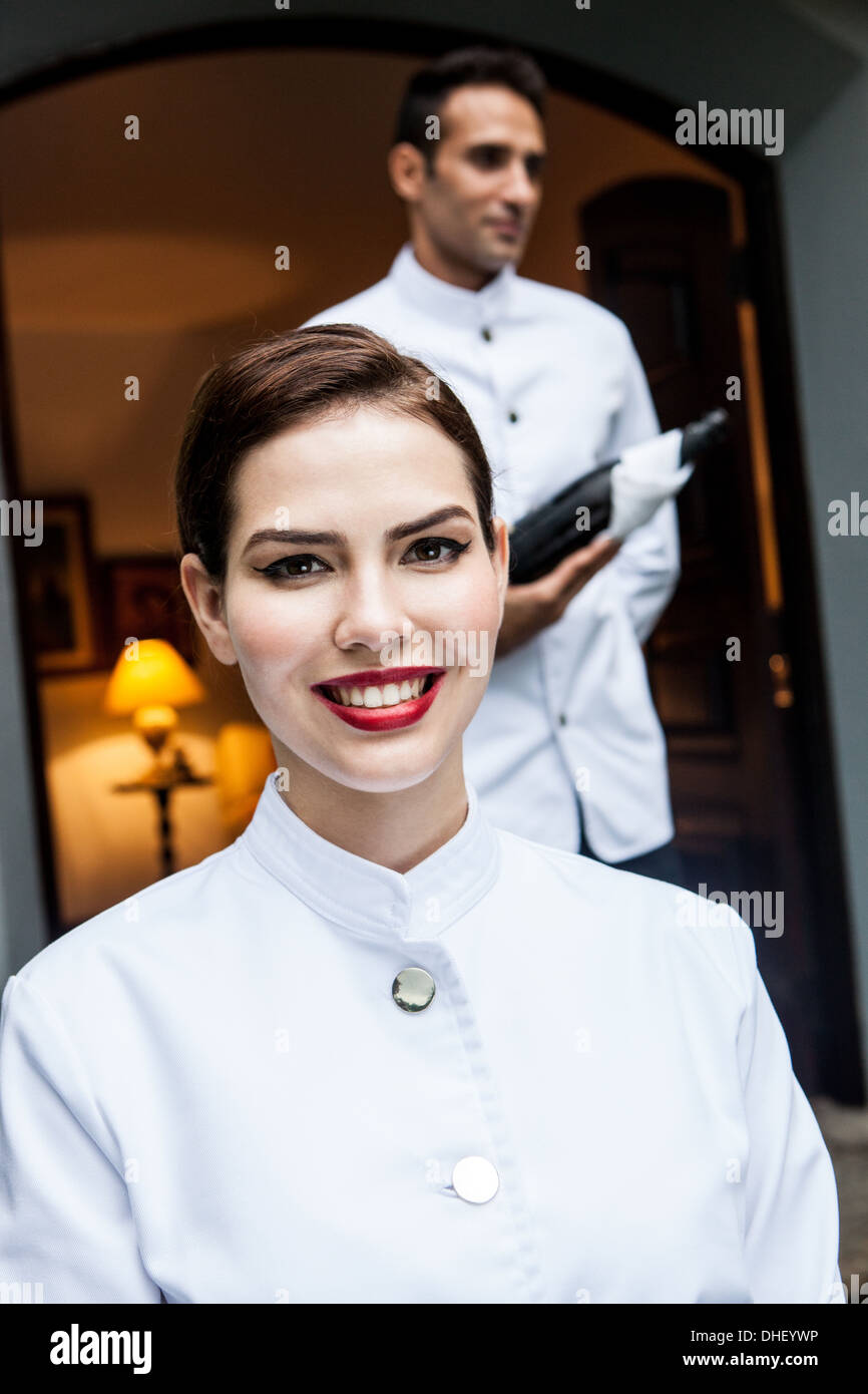 Staff at hotel entrance with bottle of champagne Stock Photo