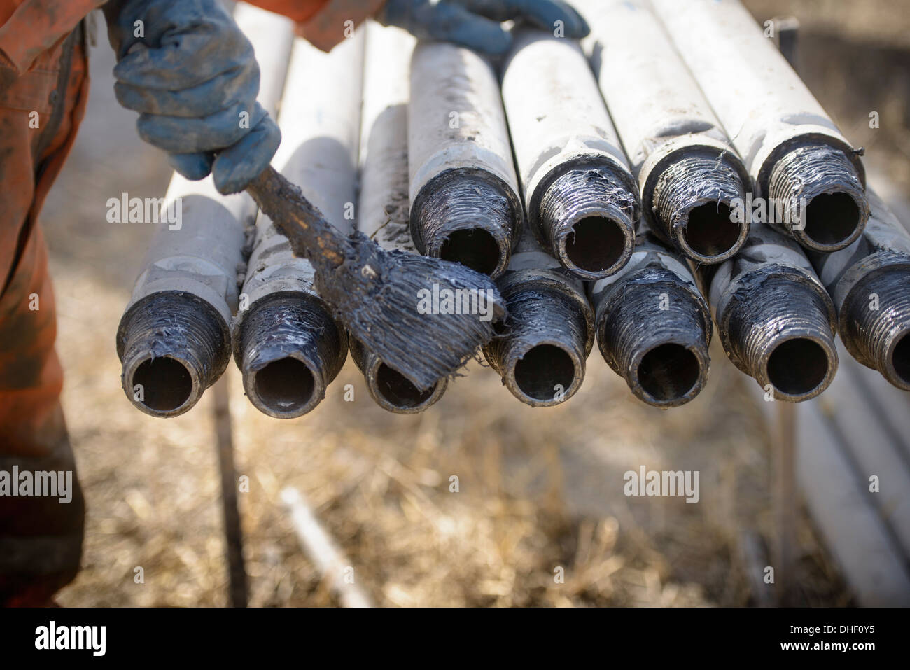 Worker preparing drilling rig connections with oil Stock Photo
