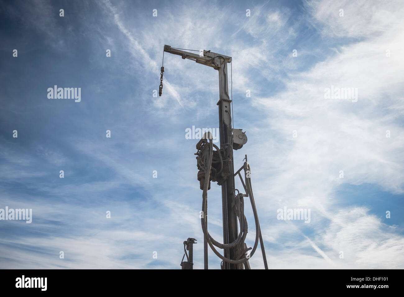 Low angle view of drilling rig against blue sky Stock Photo