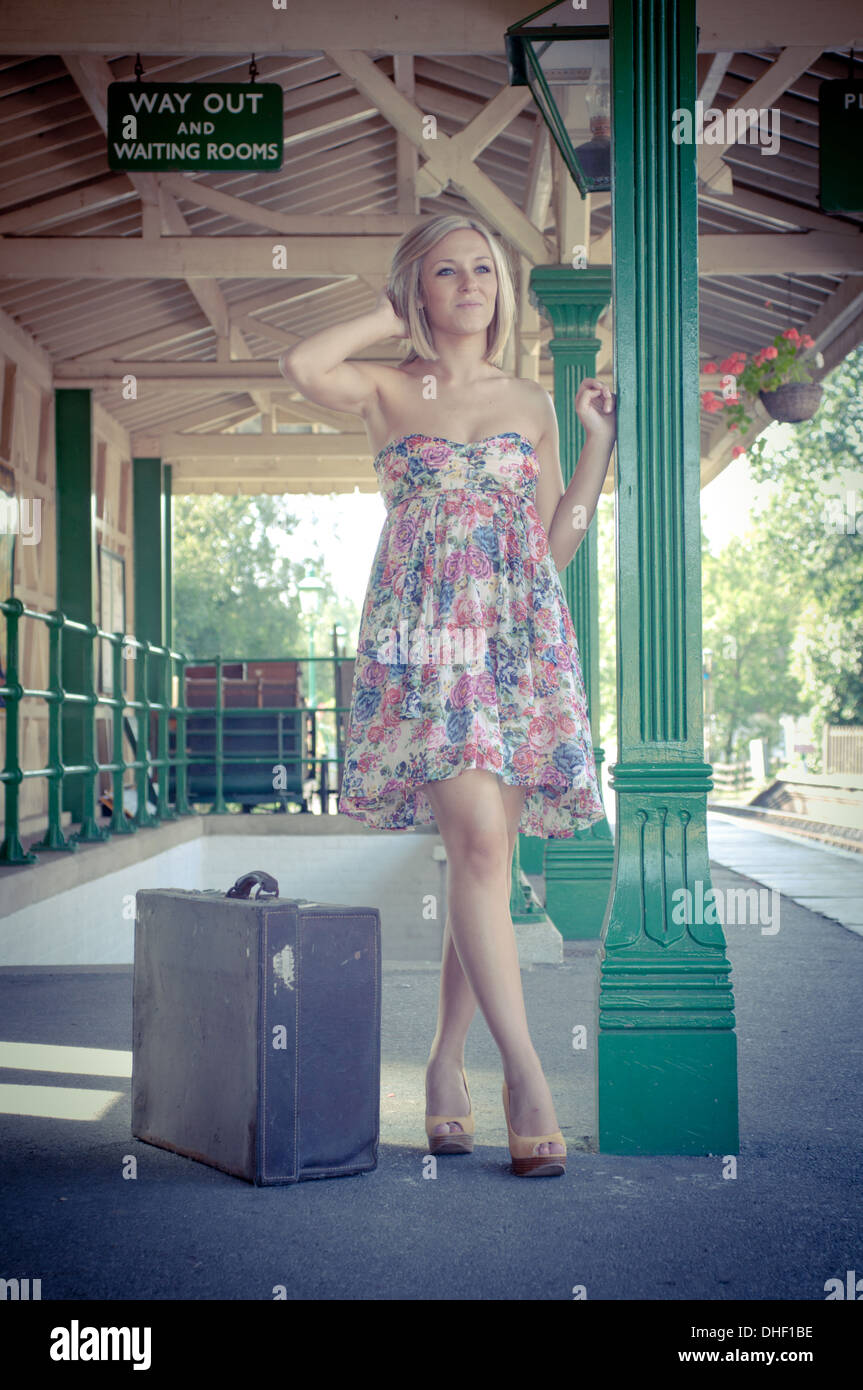Young pretty blond girls waiting at a vintage railway station Stock Photo