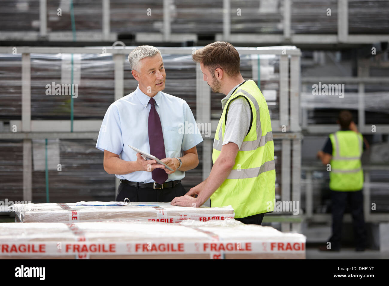 Warehouse worker and manager discussing order in engineering warehouse Stock Photo
