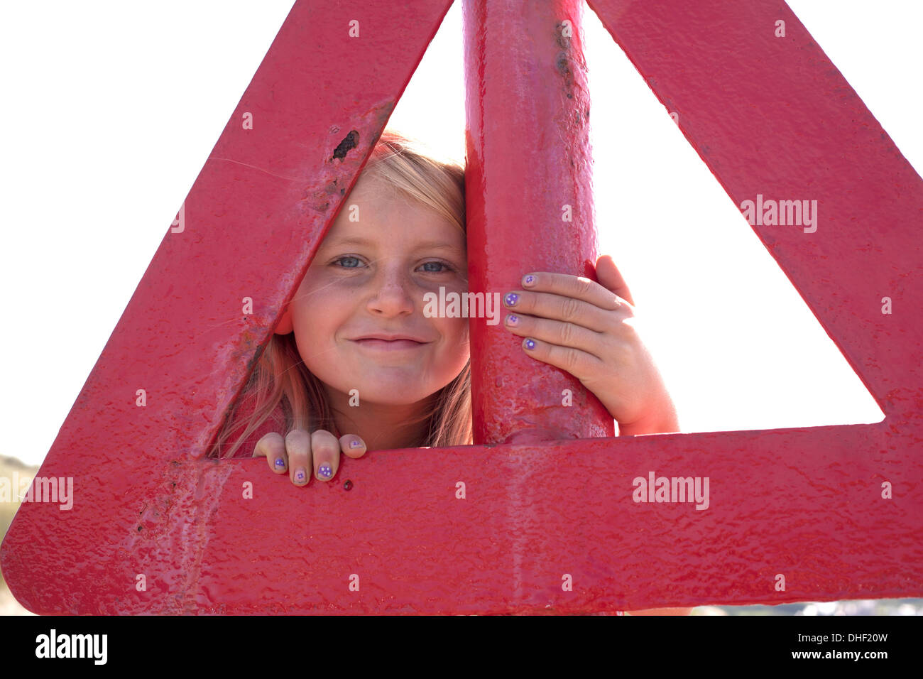 Portrait of girl looking through red triangle, Wales, UK Stock Photo