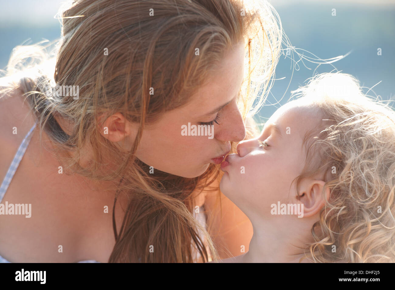 Portrait of young girl kissing older sister Stock Photo