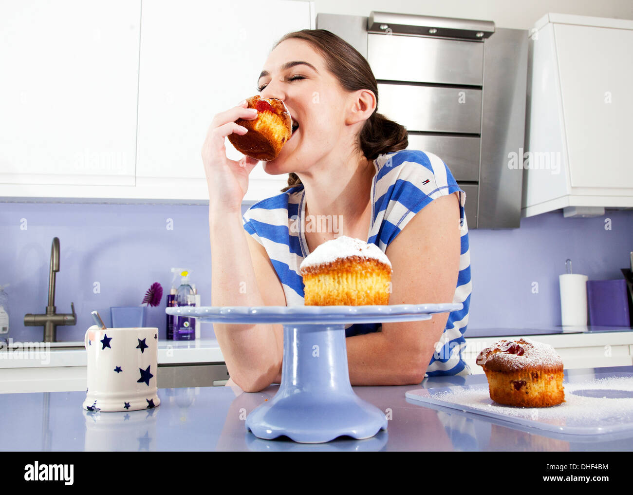 Young woman eating muffin Stock Photo Alamy