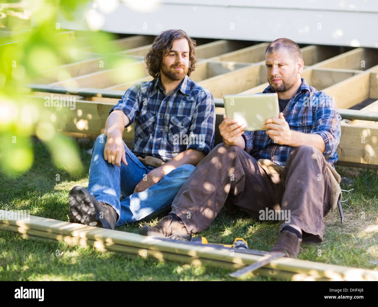 Manual Workers Using Digital Tablet At Construction Site Stock Photo