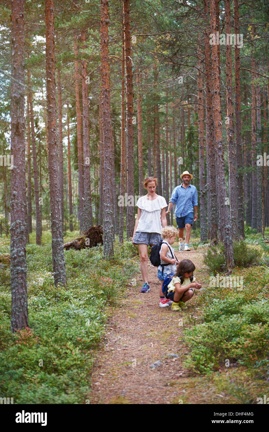 Parents walking through forest with daughters Stock Photo