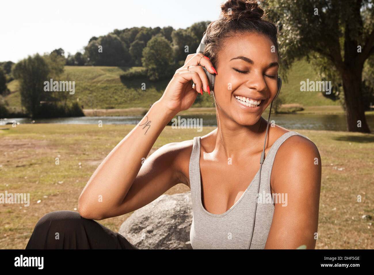 Young woman enjoying music in park Stock Photo