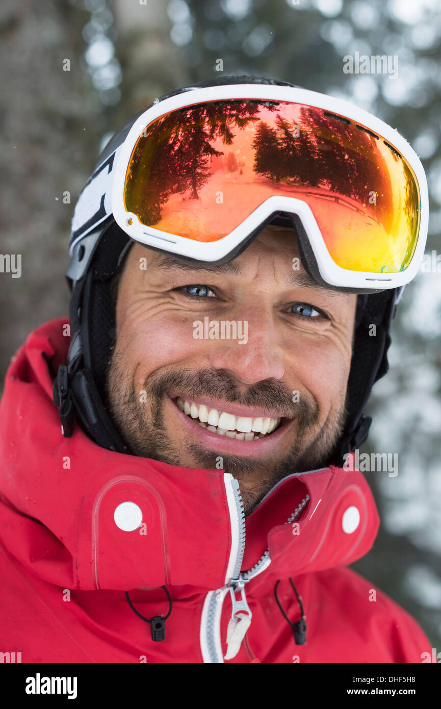 Mid adult man with ski goggles, smiling Stock Photo