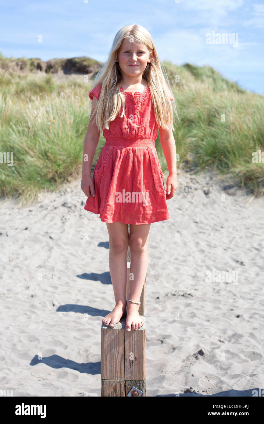 Portrait of girl standing on wooden groyne, Wales, UK Stock Photo