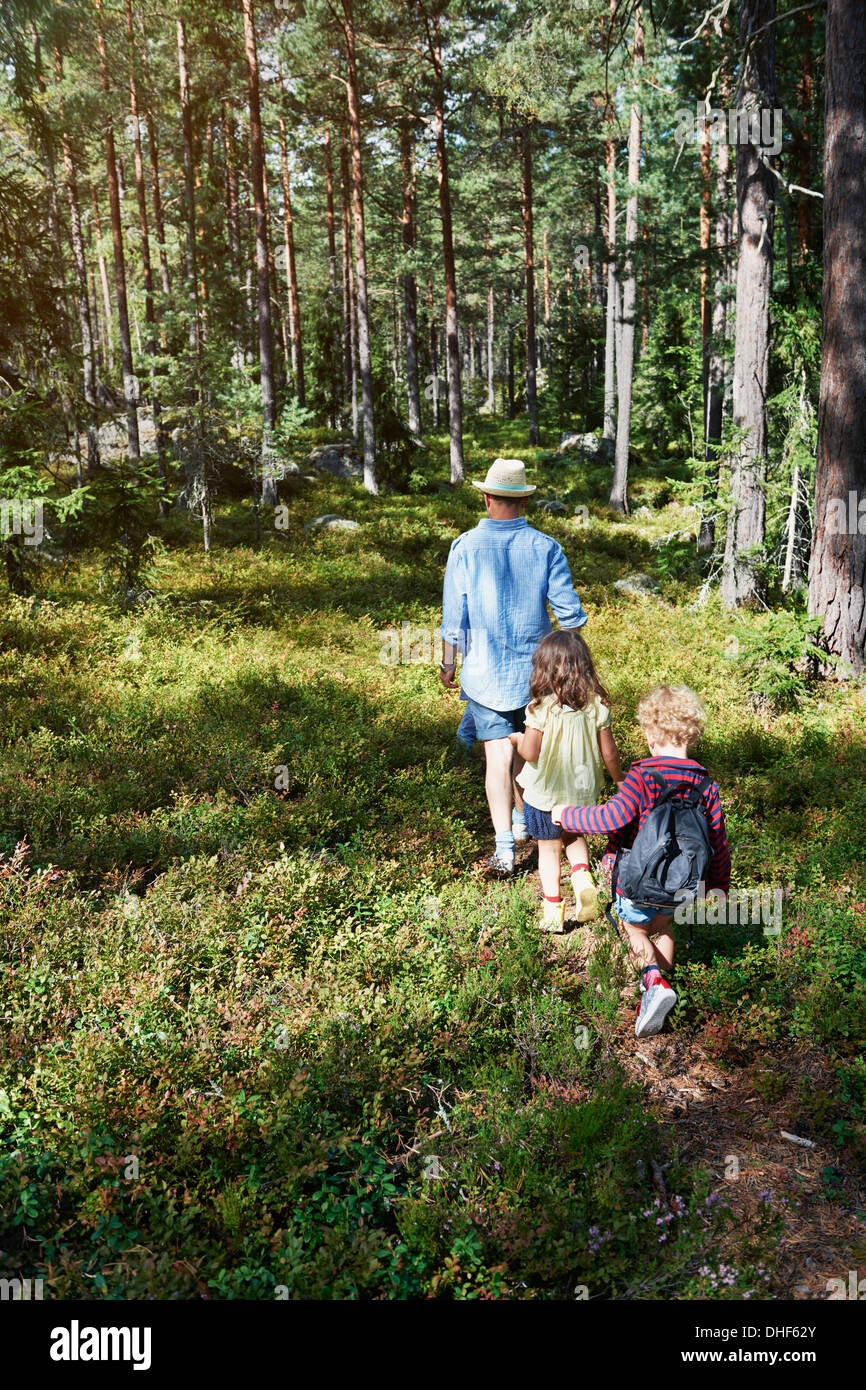 Father and daughters walking through forest Stock Photo