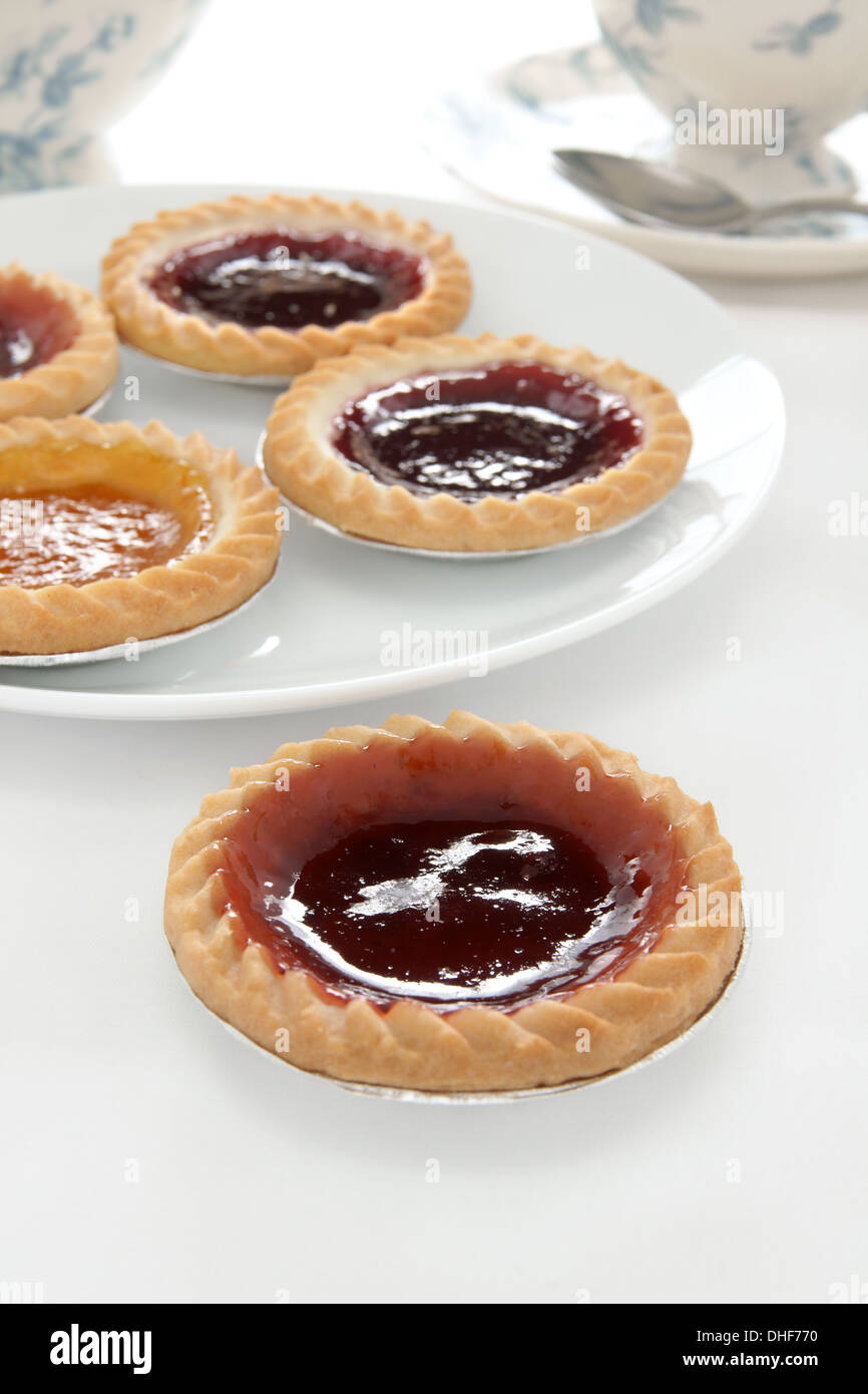 Jam tarts and afternoon tea on a white table cloth Stock Photo